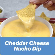 a person dipping cheese into a bowl of nacho dip