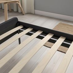 the bed frame is made out of wood and has black slats on it's sides