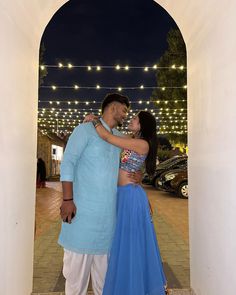 a man and woman standing next to each other in front of a building at night