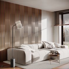 a modern living room with white furniture and wood slats on the wall behind it