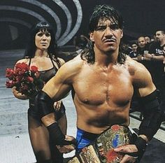 the wrestler is holding his belt and posing for a photo with two women behind him