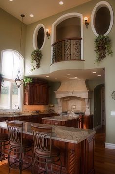 a large kitchen with an island in the middle and two stools at the counter