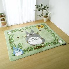 a rug with totoro and other animals on it in front of a window