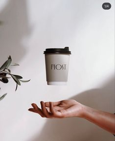 a hand holding a coffee cup with the word hot on it flying through the air