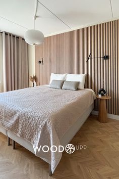 a large bed sitting in the middle of a bedroom next to a wooden floor and wall