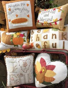 a bunch of pillows that are on top of a rack with pumpkins and other items