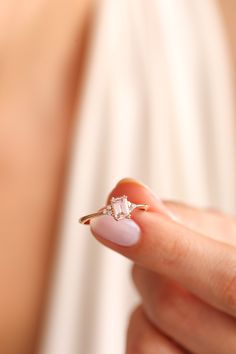 a woman's hand holding an engagement ring