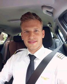 a man in uniform sitting in the back seat of a car