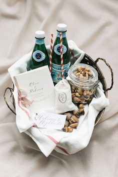 a basket filled with nuts and drinks on top of a white cloth covered tablecloth