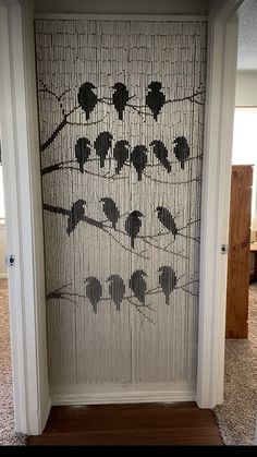 a door decorated with birds on a wire mesh fence and wood flooring in front of it