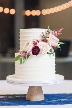 a white wedding cake with pink flowers and greenery