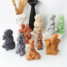 a group of small ceramic animals sitting next to each other in front of a vase