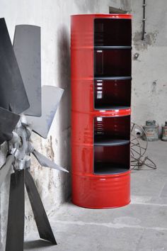 a large metal object sitting next to a red barrel