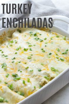 a white casserole dish filled with chicken enchiladas