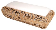 a wooden bench with white cushions on it's sides and an intricately carved design