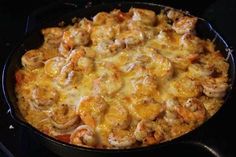 a casserole dish with shrimp and cheese on the top, ready to be eaten