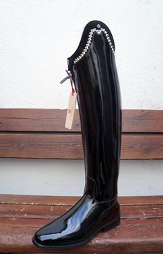 a pair of black boots sitting on top of a wooden bench