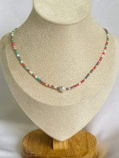 Uniquely crafted, this colorful seed bead necklace features a single lustrous pearl as its centerpiece, radiating elegance and charm. Hand-threaded with precision, the delicate multicolored seed beads create a shimmering backdrop, accentuating the timeless beauty of the solitary pearl. Designed to withstand water, this necklace is as resilient as it is captivating. Available in lengths of 14, 15 and 16 inches, it serves as a fun accessory, effortlessly adding a touch of refinement to any outfit. Beaded Pearl Necklace, Beach Necklace, Beach Necklaces, Necklace Layering, Necklace Beaded, Seed Bead Necklace, Bead Jewelry, Seed Bead Jewelry, Bead Necklace