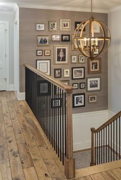 a staircase with pictures on the wall and a chandelier