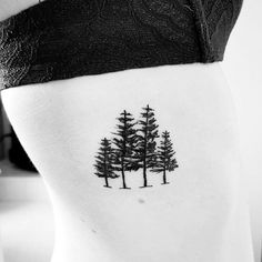 black and white photo of pine trees on the back of a woman's stomach