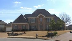 a large brick house sitting on the side of a road next to a fire hydrant