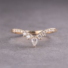 a yellow gold ring with three pear shaped diamonds on the side and two smaller pear shaped diamonds on the other side