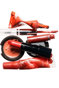 an assortment of cosmetics and makeup products displayed on a white background, including lipsticks