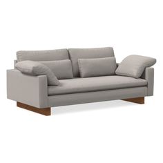 a gray couch with pillows on it and a wooden frame around the armrests