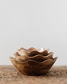 three wooden bowls are stacked on top of each other, one is made out of wood