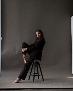 a woman sitting on top of a stool