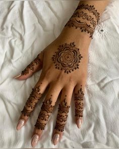 a woman's hand with henna tattoos on it