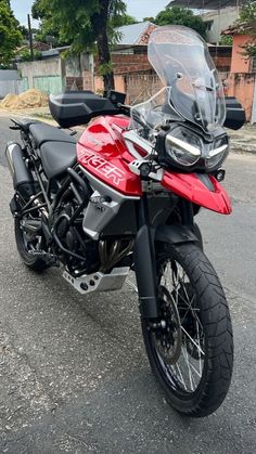 a red and black motorcycle parked on the street