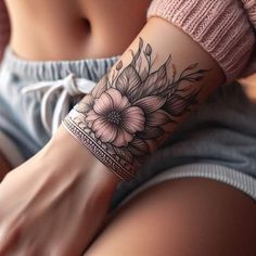 a woman's arm with a flower tattoo on the side of her left arm