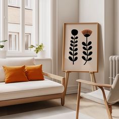 a white couch sitting next to a painting on top of a wooden easel in front of a window