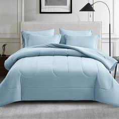 a bed with blue comforters and pillows in a room