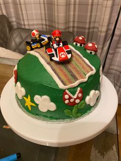 a green cake with mario kart on top