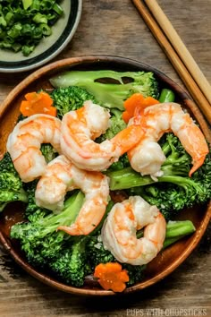 shrimp and broccoli served in a bowl with chopsticks on the side