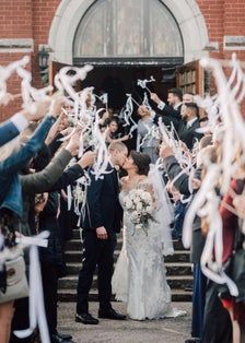 a bride and groom are walking down the aisle as confetti is thrown around them