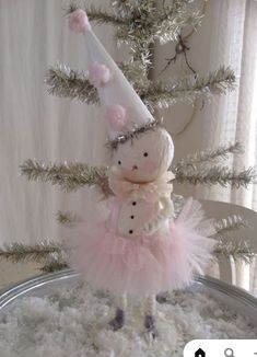 a stuffed animal in a pink tutu skirt and snowman hat on top of a tin can