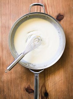 a whisk in a saucepan on a wooden table