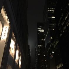 a city street at night with skyscrapers lit up