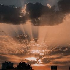 the sun is shining through the clouds above some buildings