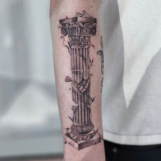 a man with a tattoo on his arm has a clock in the form of a column