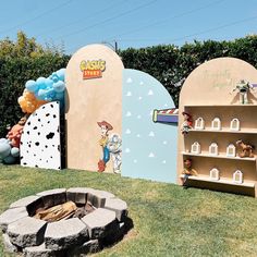 there is a fire pit in the middle of this yard with decorations on it and shelves for books