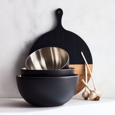 three bowls and two chopsticks on a counter