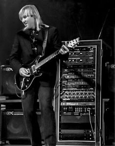 a woman standing next to a guitar on top of a stage