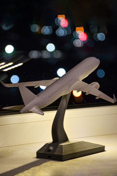 a model airplane sitting on top of a table in front of a window at night