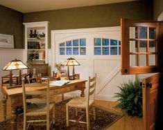 a table with two lamps on top of it in front of a door and window