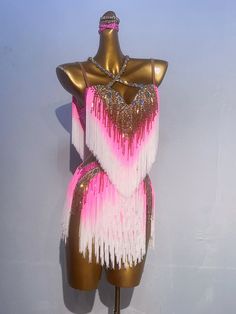 a mannequin with pink and white fringes on it's torso, standing in front of a wall