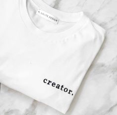 "Embroidered Unisex T-shirt with \"creator.\" embroidery on left chest. Celebrate being a creator with this classic t-shirt. COLOR= White with Black Embroidery This t-shirt is everything you've dreamed of and more. It feels soft and lightweight, with the right amount of stretch. It's comfortable and flattering for both men and women.  True to size, length is long- perfect for tucking into jeans. * 100% combed and ring-spun cotton  * Fabric weight: 4.2 oz (142 g/m2) * Pre-shrunk fabric * Side-seamed construction * Shoulder-to-shoulder taping Follow me for more!: Instagram: @alalitedesign Pinterest: @alalitedesign" Message T Shirts, Minimalist Shirts, Tee Shirt Fashion, Shirt Sayings, Cat Mom Shirts, Soul Sister, Cute Shirt Designs, Fun Shirt, Black Embroidery